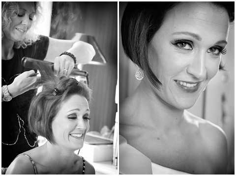 Black-and-white diptych capturing a bride during the getting-ready phase. The left panel shows a hairstylist using a curling iron to style the bride's short hair, with the bride smiling and wearing a dark strapless top and a layered necklace. The right panel is a close-up portrait of the bride after her hair and makeup are complete, showing defined eye makeup, a teased updo, and a drop earring, with a white dress strap visible at the shoulder. Both images have soft contrast and mid-range tones. Side-by-side portrait and detail composition.