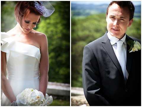 A side-by-side portrait diptych showing the bride and groom separately, likely taken outdoors before or during the ceremony. The bride wears a strapless ivory dress with a structured origami-style shoulder detail and a small blue birdcage fascinator, and holds a bouquet of white orchids and phalaenopsis blooms; she is looking downward. The groom wears a dark charcoal suit with a light blue tie and a white floral boutonniere, and is photographed against a backdrop of green hills. Both are close-up portrait shots with a shallow depth of field.