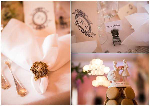 A three-part detail flat lay composite showcasing reception table styling with a classic French-inspired theme. The left panel shows a white folded napkin secured with an antique gold cameo brooch napkin ring alongside silver cutlery. The top right panel features a place card reading 'Bon Appétit' next to a monogrammed paper menu or program printed with ornate black ink framing and a miniature black chair figurine as a table decoration. The bottom right panel shows a Ladurée-branded macaron tower topped with a white porcelain bride and groom cake topper figurine, lit from behind by warm bokeh lights. The overall decor palette is white, gold, and blush, with a refined Parisian-inspired styling theme.