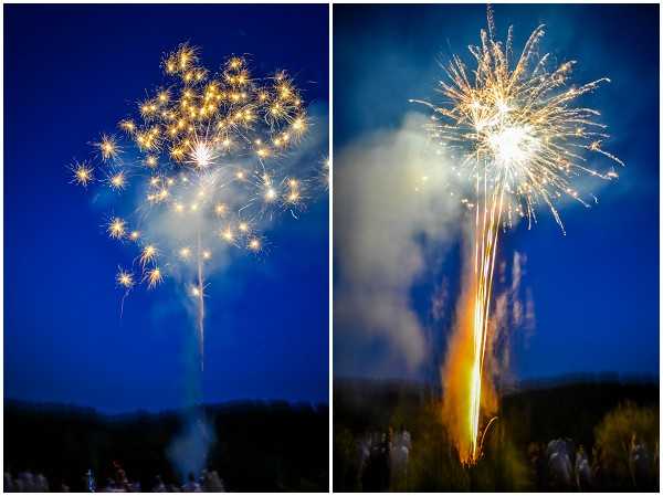 A side-by-side diptych of a wedding fireworks display photographed at night against a deep blue sky. The left panel shows a cluster of gold and white star-burst fireworks exploding in a scattered formation, while the right panel captures a single large white and gold burst with a bright orange launch trail still visible at ground level. Silhouetted tree lines and what appear to be guests watching are faintly visible at the bottom of both frames. The shots are wide-angle captures focused on the pyrotechnic display rather than the wedding party.
