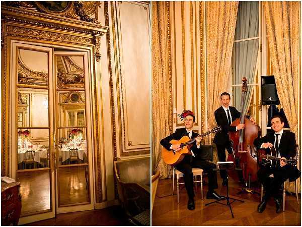 A split image showing two views of an indoor wedding reception at a grand Parisian-style ballroom or hôtel particulier. The left panel shows ornate gold-framed mirrored doors reflecting the reception room beyond, where round tables dressed in white linens with red floral centerpieces and gold chiavari chairs are visible. The right panel shows a three-piece live band performing at the reception: two musicians playing acoustic guitars and one playing a double bass, all dressed in black suits with black ties. The musicians are seated on bar stools in front of floor-to-ceiling gold silk drape curtains. The interior decor features gilded moldings, parquet flooring, and warm ambient lighting, consistent with a classic French formal venue aesthetic. Wide editorial-style composition capturing both the room detail and the entertainment setup.
