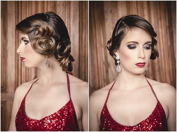 A styled bridal beauty shoot showing two portrait views — profile and three-quarter front-facing — of the same woman, presented as a side-by-side diptych. The subject wears a deep red sequined halter-neck dress and crystal teardrop chandelier earrings. Her hair is styled in a vintage-inspired finger-wave updo with pinned curls at the nape. Her makeup features smoky eye shadow in dark charcoal tones, defined brows, and a deep red lip. The overall styling references a 1920s–1930s Art Deco aesthetic. The background consists of warm brown draped fabric, providing a neutral studio-style backdrop. Both shots are close-up portraits with soft, even lighting.