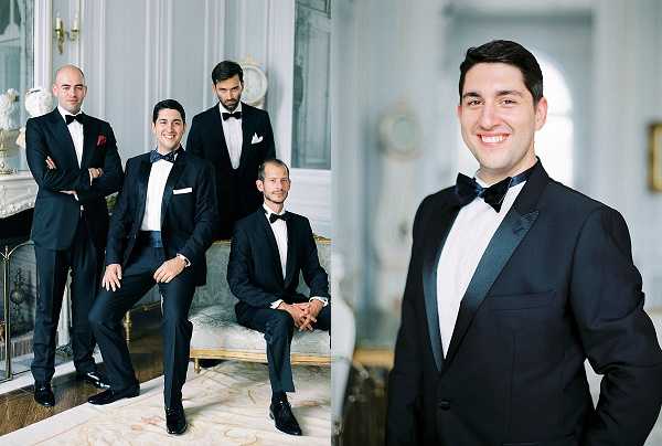 A side-by-side portrait set showing the groom and his groomsmen getting ready or posing indoors, likely inside a French chateau with ornate white-and-gold paneling, a decorative fireplace, and a carved settee visible in the background. The left image is a group portrait of four men — three standing and one seated — all dressed in classic black tuxedos with white dress shirts and black bow ties, with one groomsman wearing a red pocket square. The right image is a close-up portrait of the groom alone, smiling directly at the camera, wearing the same black tuxedo and bow tie style. The styling is formal and classic, consistent across the group, and the interior decor reflects a traditional French aristocratic aesthetic with pale walls and ornamental furnishings.