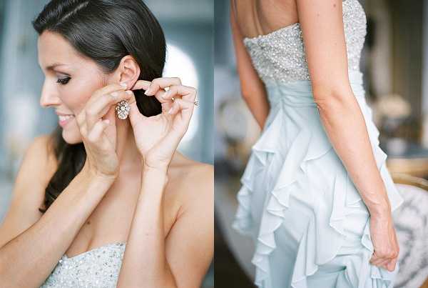 A diptych of close-up detail shots taken during the getting-ready portion of a wedding. The left image shows the bride fastening a large crystal cluster earring, with her dark hair swept back and light makeup; she wears a strapless beaded or sequined bodice. The right image captures the back of the bride's pale mint/ice blue strapless gown, which features a heavily beaded and crystal-embellished upper bodice and a tiered ruffle skirt. Both shots are softly lit with a film-style, slightly warm tone and focus on jewelry and dress details rather than full-length composition.