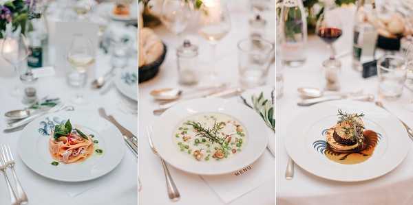 A triptych of close-up detail shots showcasing three plated courses served at a wedding reception dinner. The left plate features a pasta dish with a pink-hued sauce and fresh herb garnish, the center plate presents a creamy risotto or soup with green peas and dill, and the right plate displays a meat medallion topped with a decorative herb garnish in a golden sauce. All three courses are served on white decorative plates with silver cutlery, set on white linen tablecloths. The table setting includes clear glassware, wine glasses with white and red wine, candles, and small floral arrangements with greenery. A printed menu card is visible near the center plate. The overall reception decor follows a classic, clean palette with white linens and soft natural lighting.