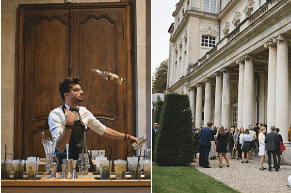 A diptych image showing two scenes from a wedding cocktail hour. On the left, a male bartender in a white shirt and dark vest is flair bartending, tossing a bottle in the air behind a bar setup with multiple glasses, cocktail shakers, and prepared drinks arranged on the counter, with large ornate wooden doors in the background. On the right, approximately 20-30 wedding guests mingle outdoors on a gravel terrace in front of a grand neoclassical building featuring tall white columns and formal manicured topiary hedges, dressed in smart-casual to formal attire. Both images are medium-wide shots taken in natural daylight. Potential venue feature image.