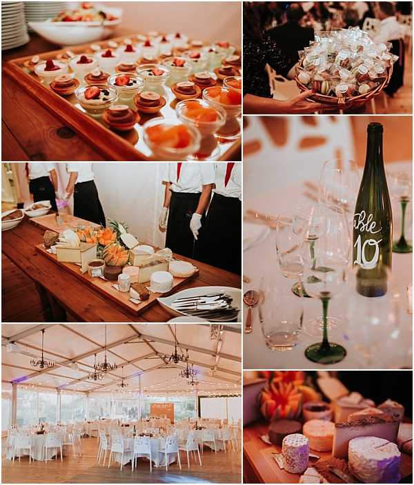 A collage of six detail and wide-shot images from a wedding reception. Top left shows a wooden tray of individual desserts including fruit tarts, chocolate cakes, and fruit cups with strawberries. Top right is a close-up of a rose gold basket holding wrapped favor boxes and macarons being carried by a guest. Middle left features white-gloved catering staff presenting a large wooden cheese board with an assortment of French cheeses, condiments, and garnishes. Middle right is a close-up detail shot of a green wine bottle used as a table number marker, hand-lettered in white cursive with 'Table 10', surrounded by crystal champagne flutes and green-stemmed glasses. Bottom left is a wide shot of the reception marquee tent interior, set with round tables covered in white linens, white ghost chairs, dark iron chandelier pendants, and fairy lights strung across the ceiling with warm ambient lighting and purple accent uplighting along the walls. Bottom right is a moody close-up of the cheese board showing various soft and aged French cheeses with orange and floral garnishes under warm lighting.