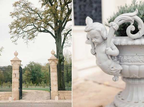 A two-image detail composite showcasing venue architecture and ornamental features. The left image is a wide shot of a formal entrance gate with tall limestone pillars topped with stone finials and black wrought-iron fencing, with a gravel driveway leading through the gate. The right image is a close-up detail of a white painted cast-iron or stone ornamental urn featuring a cherub figure in relief, with a small topiary planted inside, positioned against a pale stone wall. No people are present in either image. The overall palette is muted — cream, grey, and soft green tones — consistent with a classic French chateau property. Potential venue feature image.