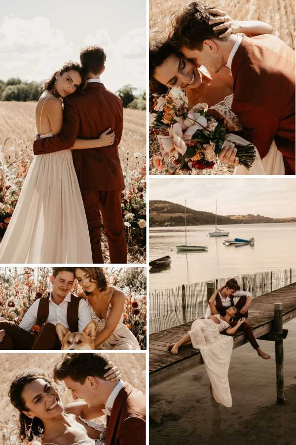 A collage of five couple portrait shots from what appears to be the same boho-rustic outdoor wedding. The bride wears a flowing ivory slip-style dress with lace detailing and thin straps, while the groom is dressed in a rust-brown suit with a matching waistcoat and white shirt throughout. The bouquet features peach, coral, cream, and deep red blooms including what appear to be proteas, garden roses, and wildflowers. Top-left shows the couple embracing in an open wheat field bordered by wildflowers in orange, red, and white tones — a wide portrait shot. Top-right is a close-up portrait of the couple leaning together smiling, bouquet held between them. Middle-left features the couple seated outdoors with a corgi dog, surrounded by dried grasses and deep red florals. Bottom-left is a close-up portrait of the couple nearly kissing, laughing, with warm golden tones. The right panel shows the couple posed on a wooden dock over a calm lake or estuary with sailboats visible in the background — a wide environmental portrait. The overall color palette is warm and earthy — terracotta, rust, ivory, and amber — consistent with a boho autumn styling theme.