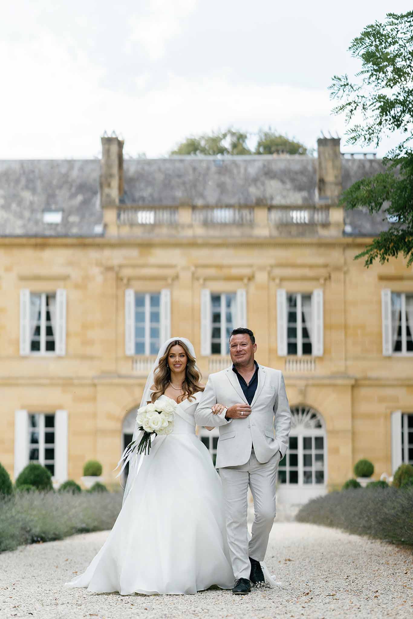 Bride and groom formal portrait in front of neoclassical château courtyard