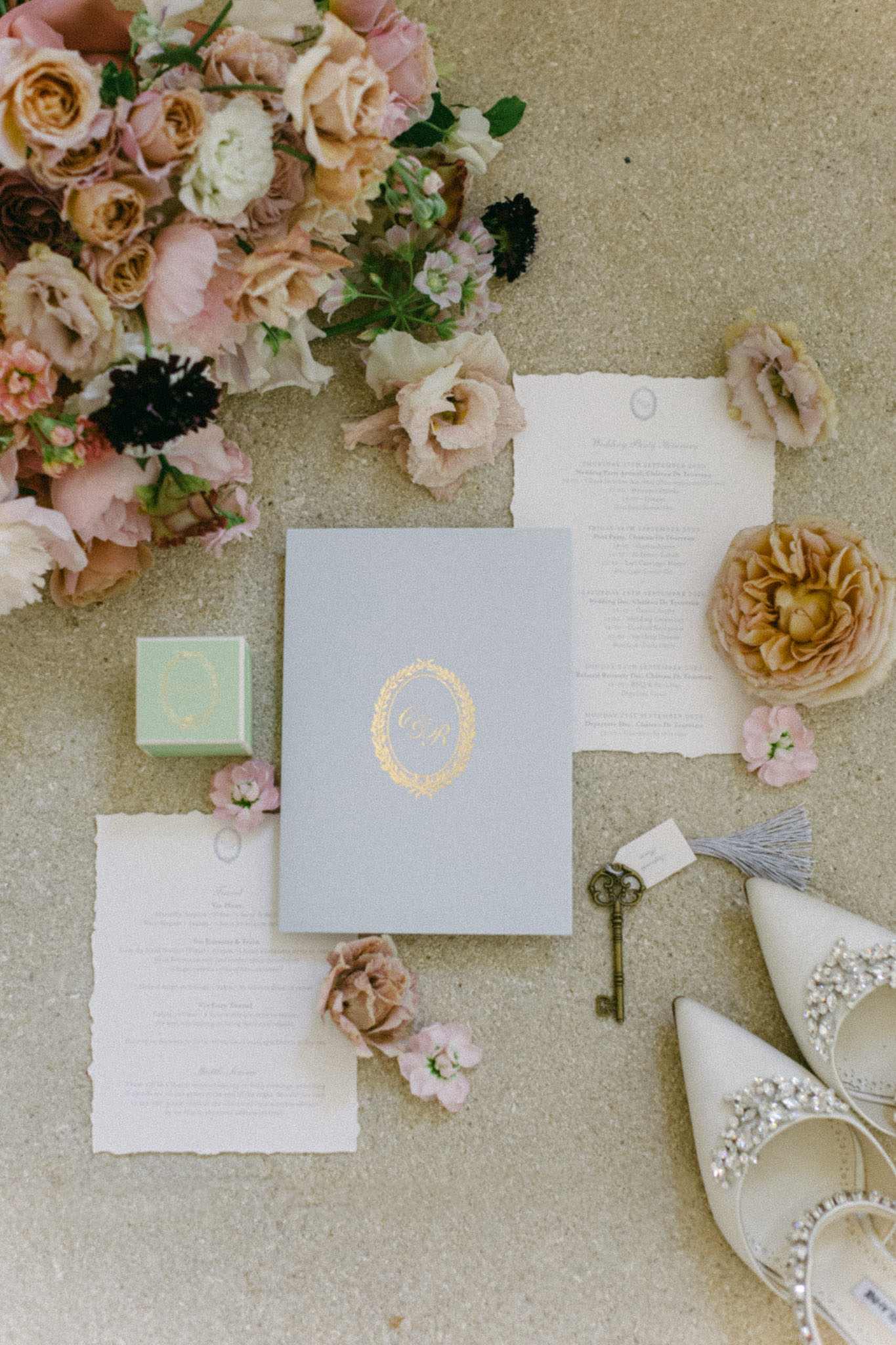Grey folio stationery with gold monogram, Jimmy Choo crystal heels, and blush garden rose bouquet