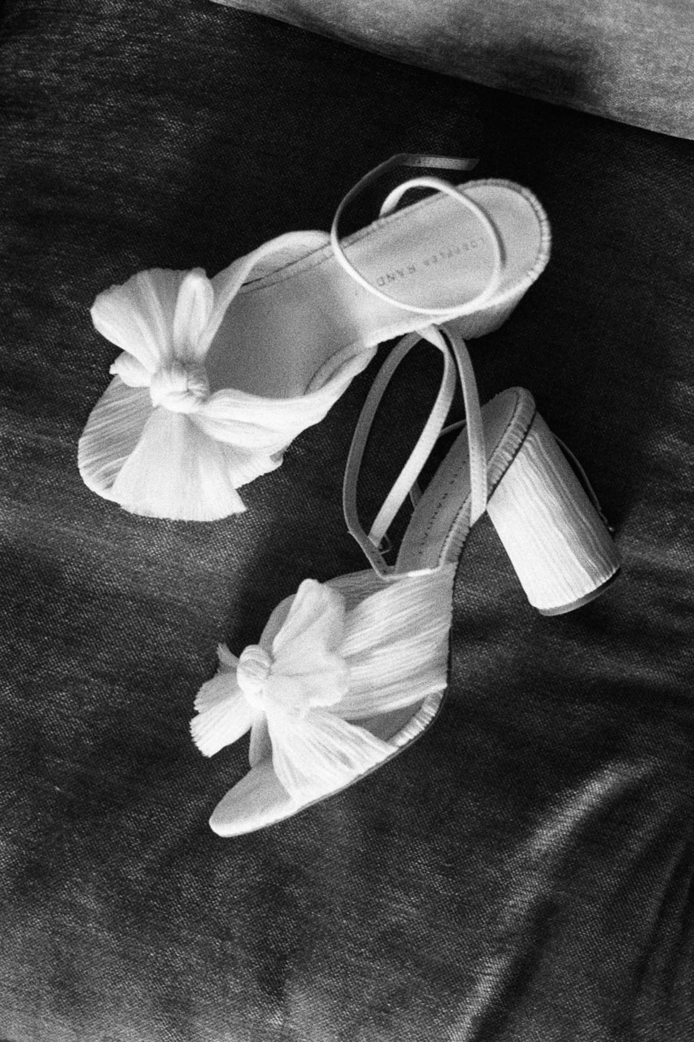 Loeffler Randall bridal sandals with pleated bow detail on draped fabric in high-contrast B&W