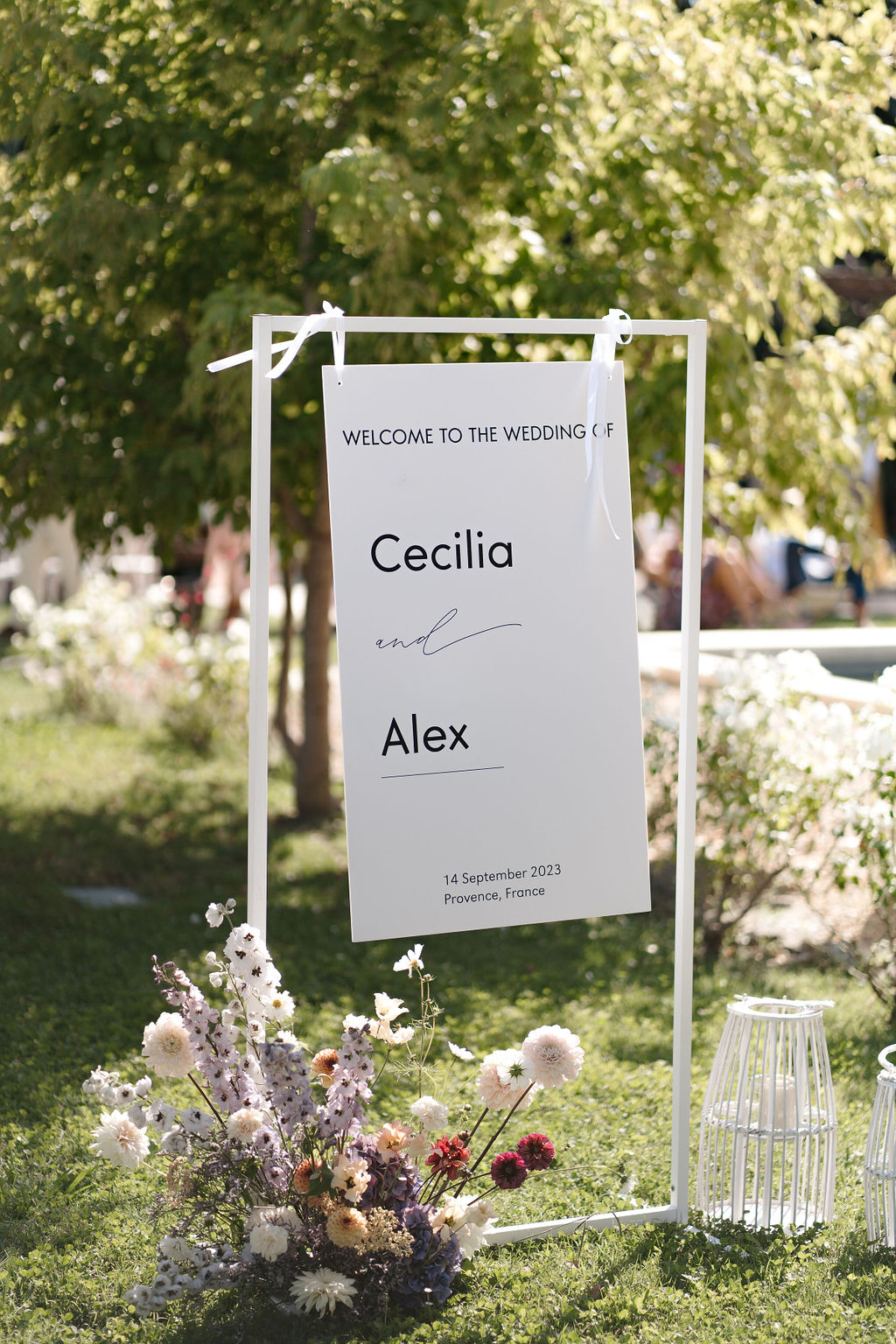 Welcome sign for Cecilia and Alex with dahlia and delphinium ground arrangement in muted tones