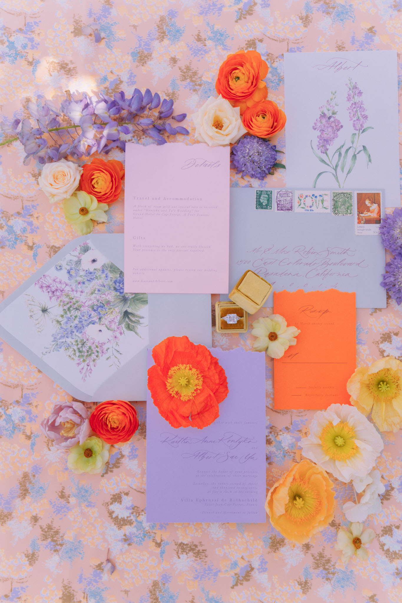 Periwinkle invitation with orange poppy, lilac details card, ranunculus, and gold velvet ring box
