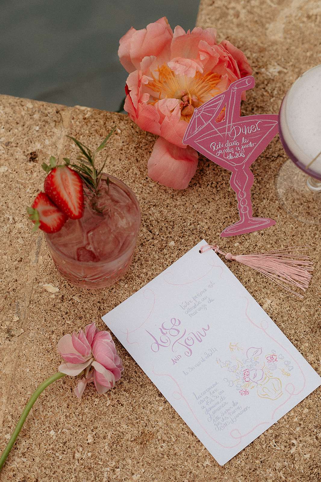 Stationery flat lay with pink cocktail coral peony die-cut drink card and hand-lettered invitation with gold and pink tassel