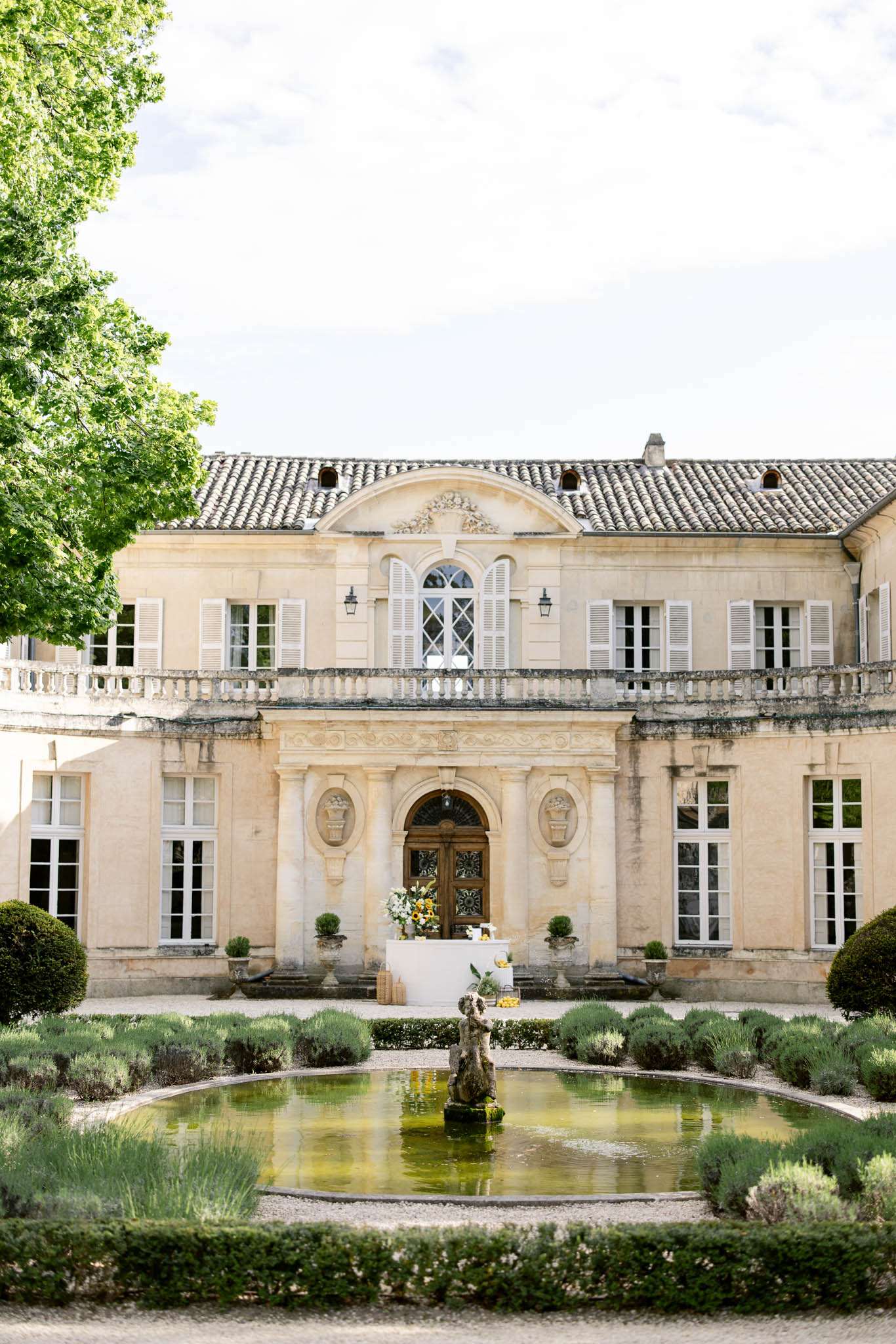 18th-century limestone chateau with ornamental pond, lavender hedges, and box topiary in formal garden