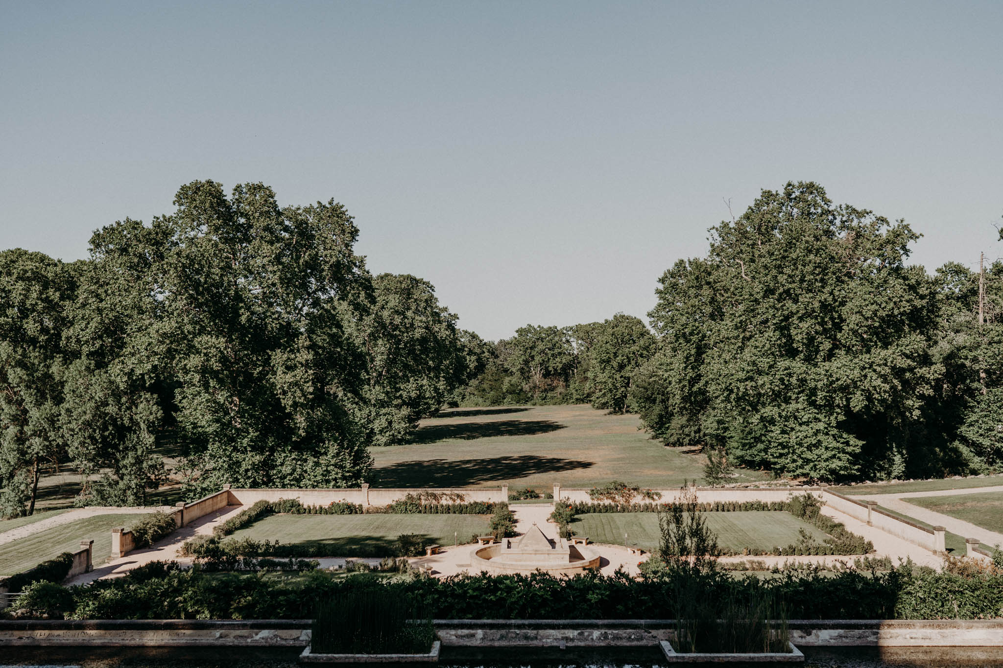 Elevated view of formal French parterre garden with clipped hedgerows, gravel paths and central fountain