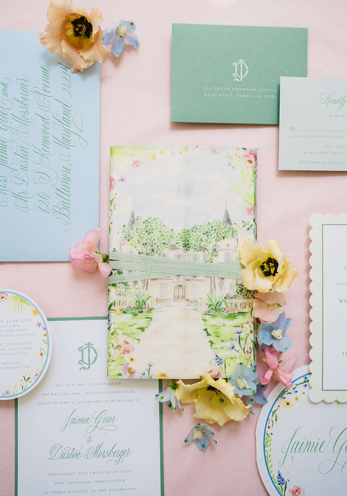 Stationery suite with watercolor chateau illustration, sage ribbon, blue envelopes, and scattered blooms