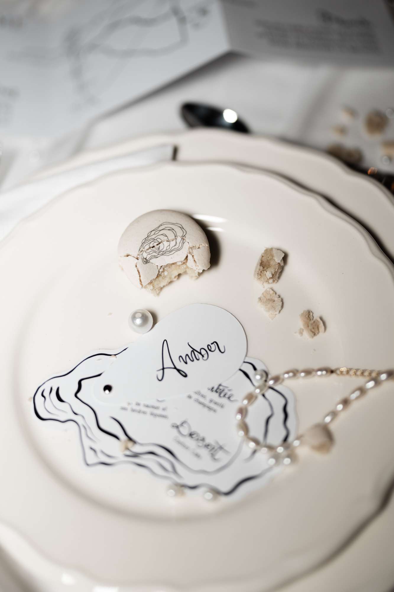 Coastal place setting with hand-drawn nautical plate, oyster shells, and pearl beading on cream-colored plate