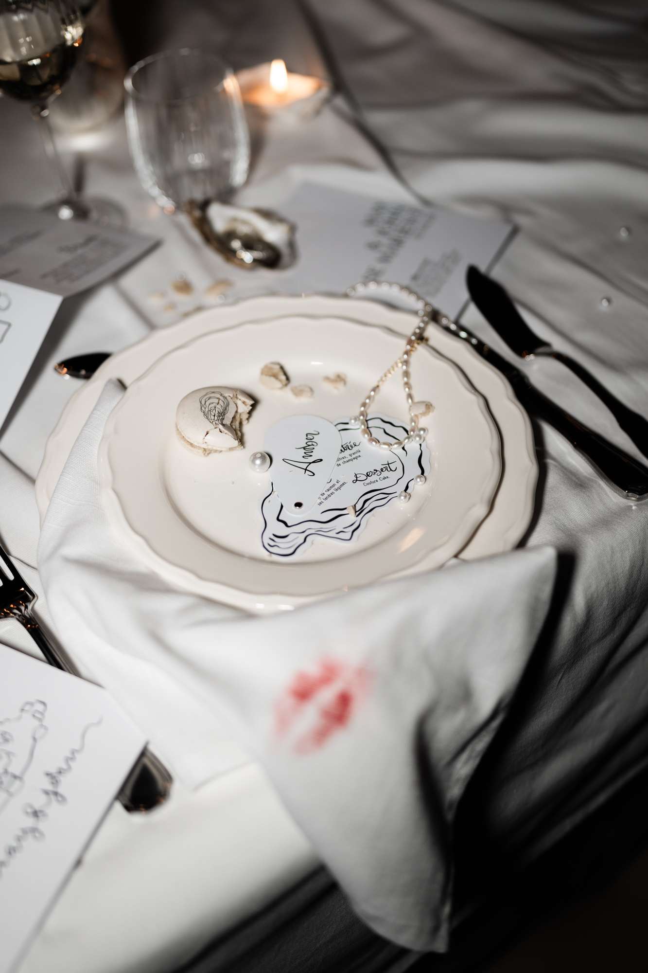 Formal place setting with custom illustrated place card, cream plate, black flatware, and gray linen napkin