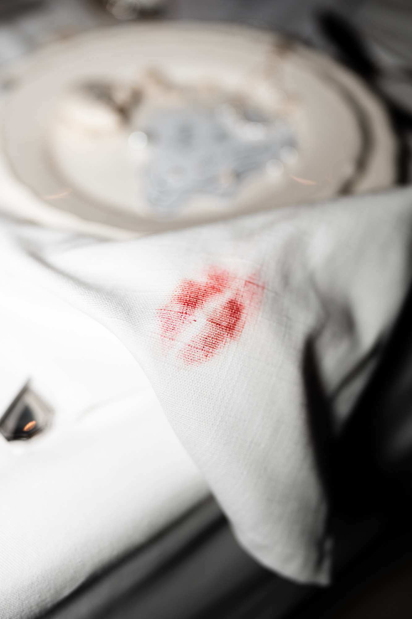 White linen napkin with red embroidered monogram initials on a formal wedding place setting