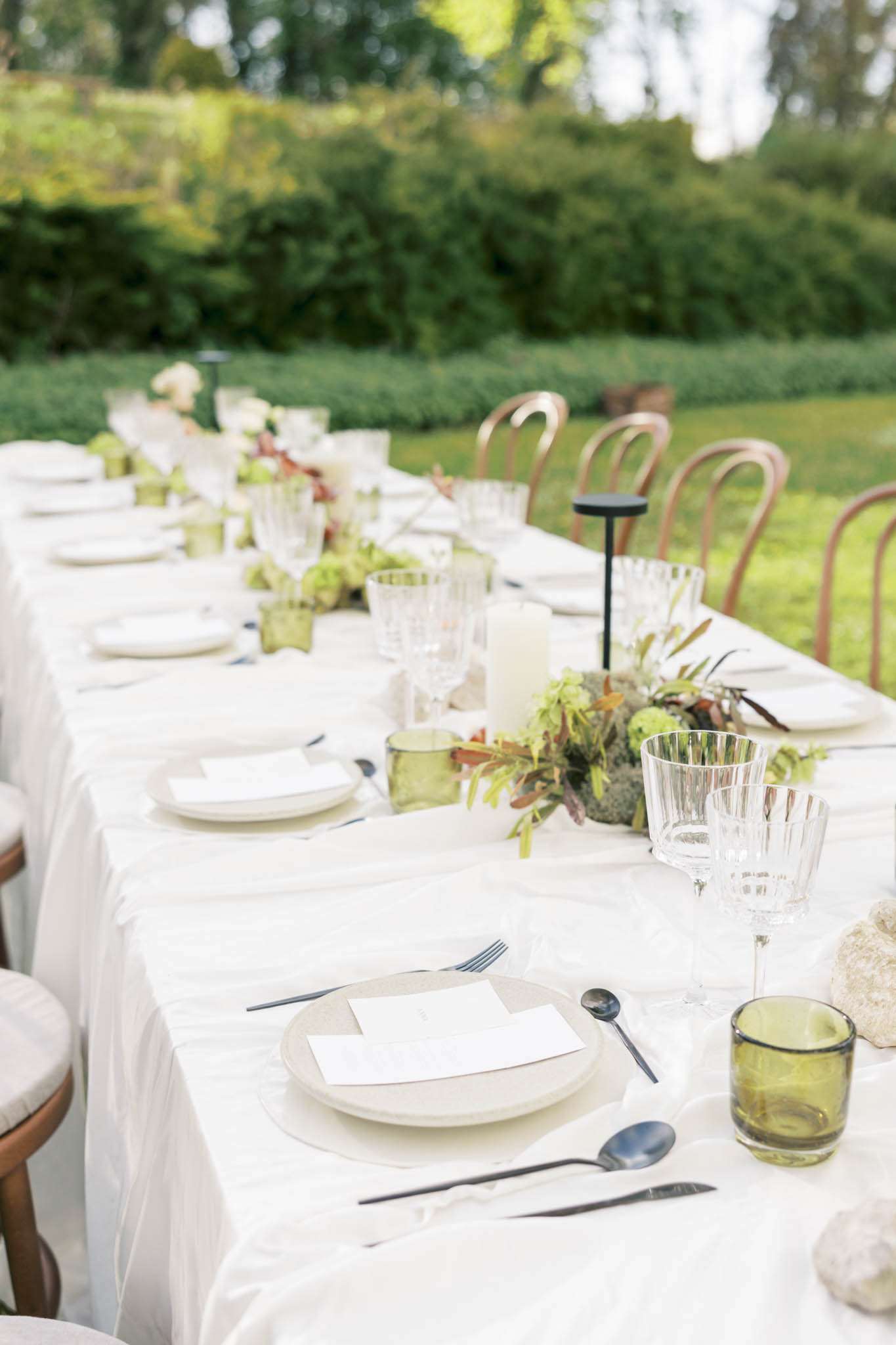 Modern organic table with matte black cutlery, olive glasses, and rust foliage with viburnum centerpieces
