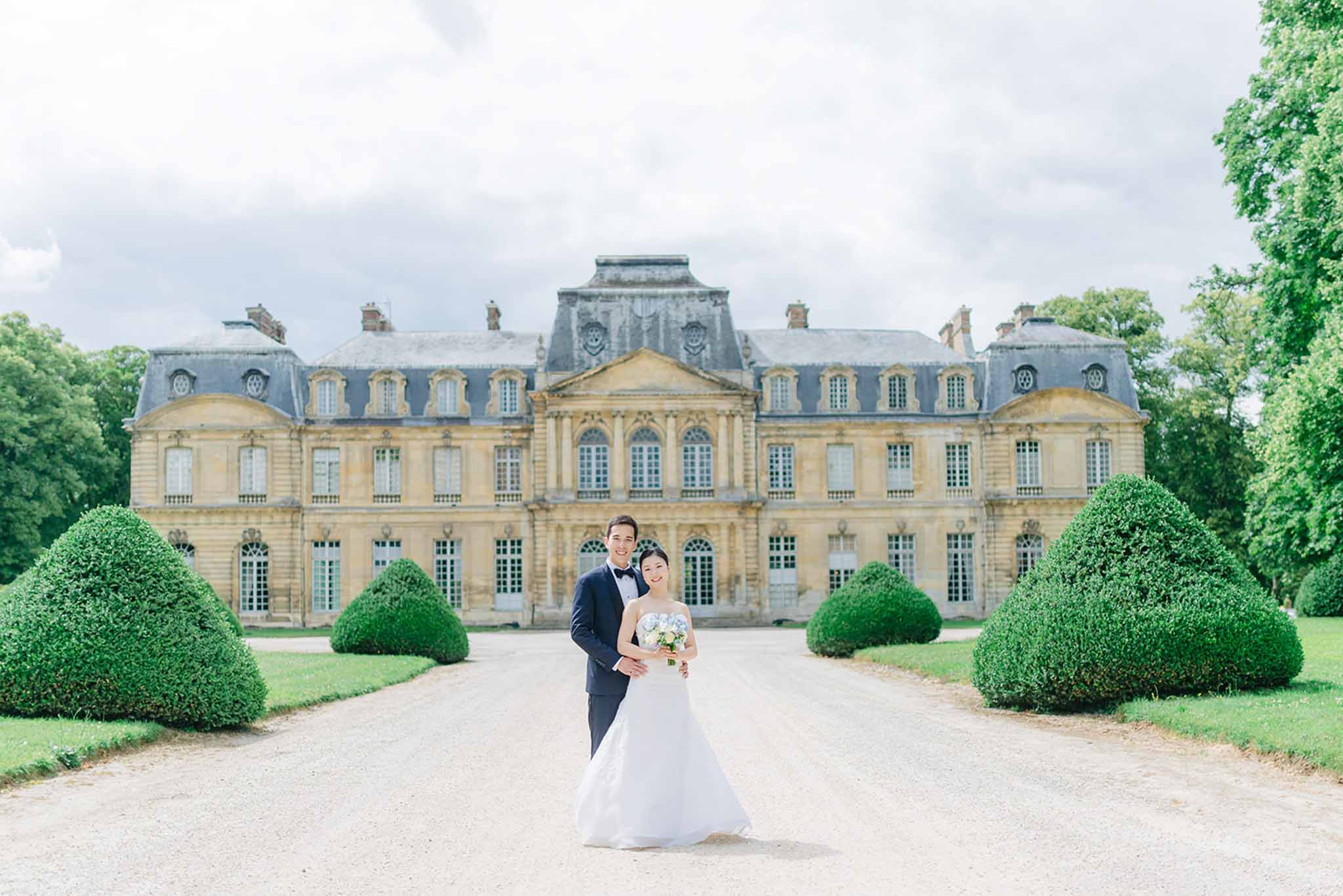 Outdoor ceremony at Château de Champlatreux with guests seated on formal grounds