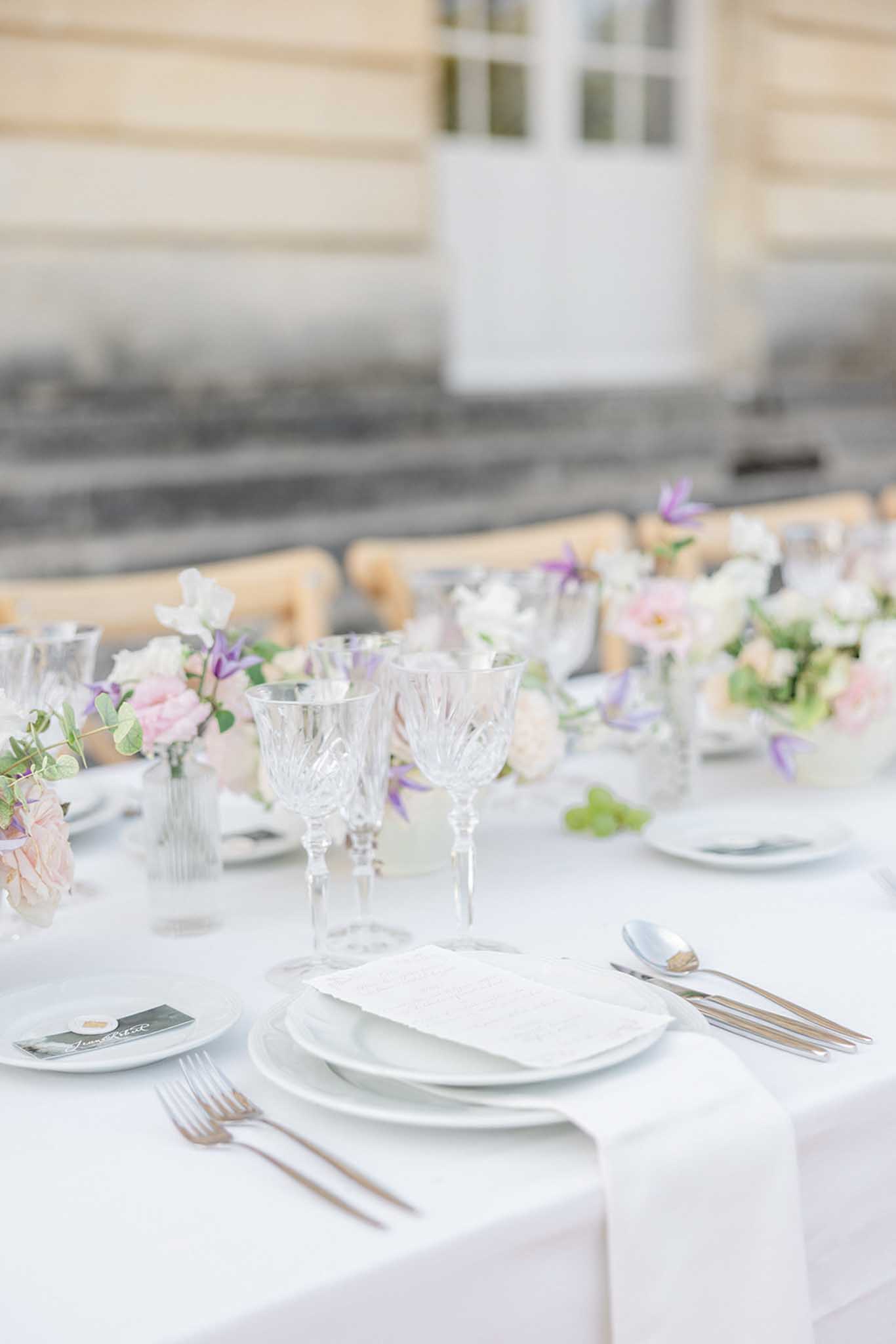 Reception table with blush runner, rose gold flatware and white and pink floral centerpieces with eucalyptus