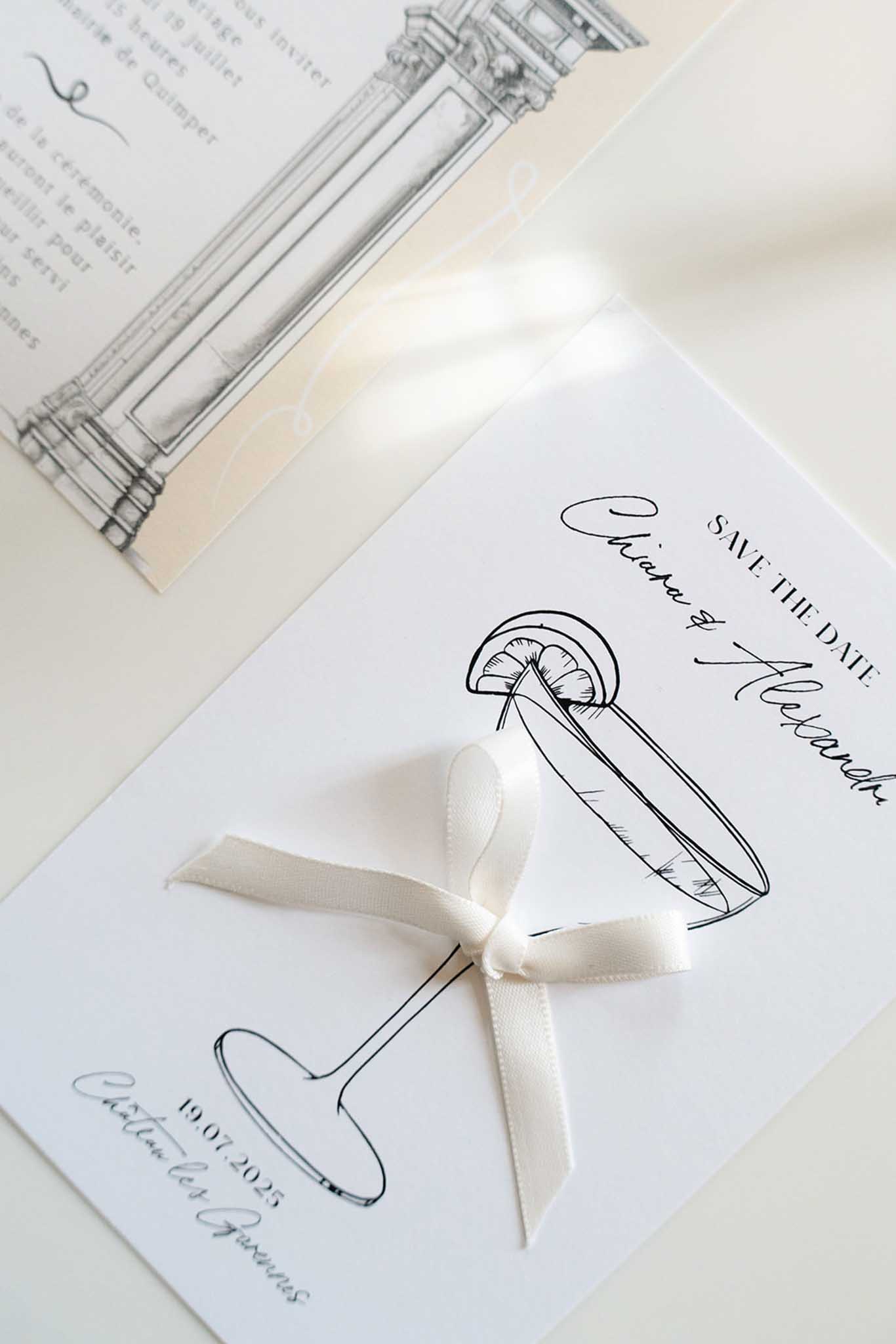 Wedding stationery flat lay with shell illustration, silk ribbon bow, and calligraphy Save the Date card