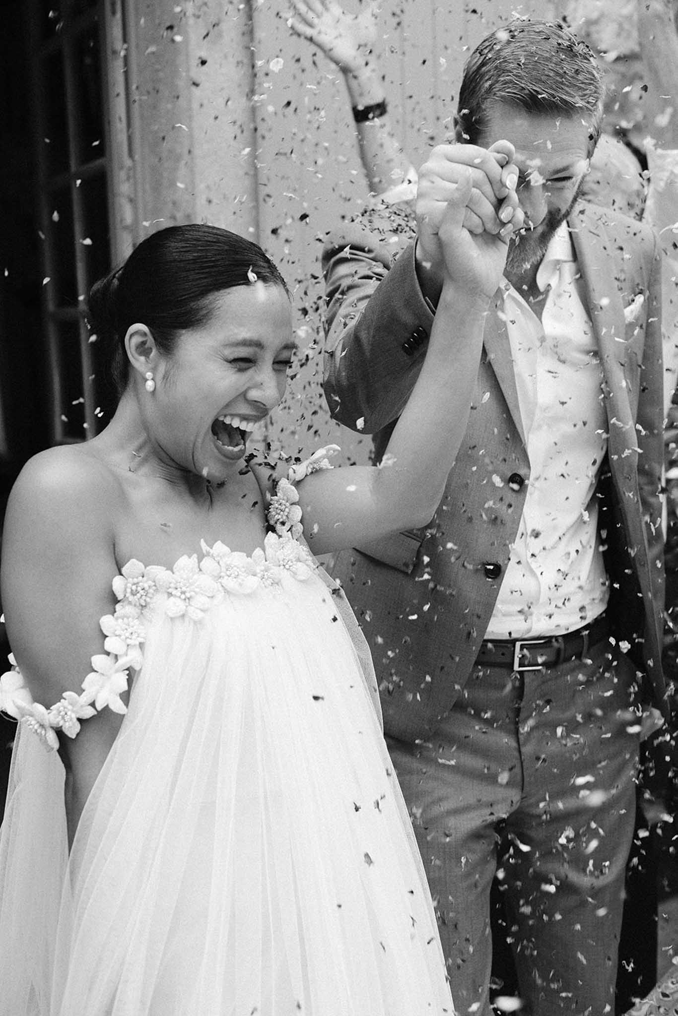 Black and white bride and groom during a confetti exit at a French chateau