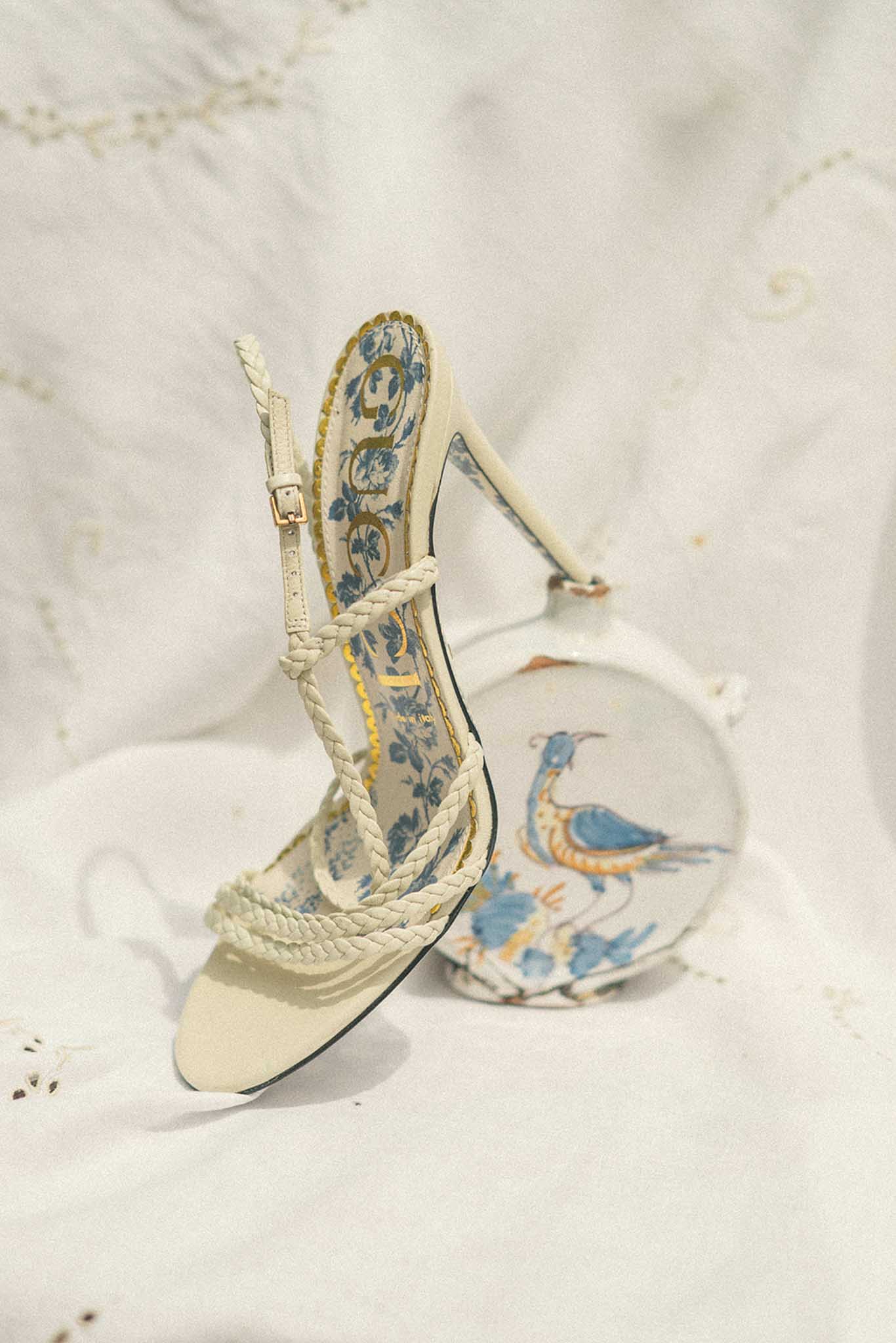 Close-up of bridal cream boots with rope ankle strap and blue and gold patterned fabric bohemian detail