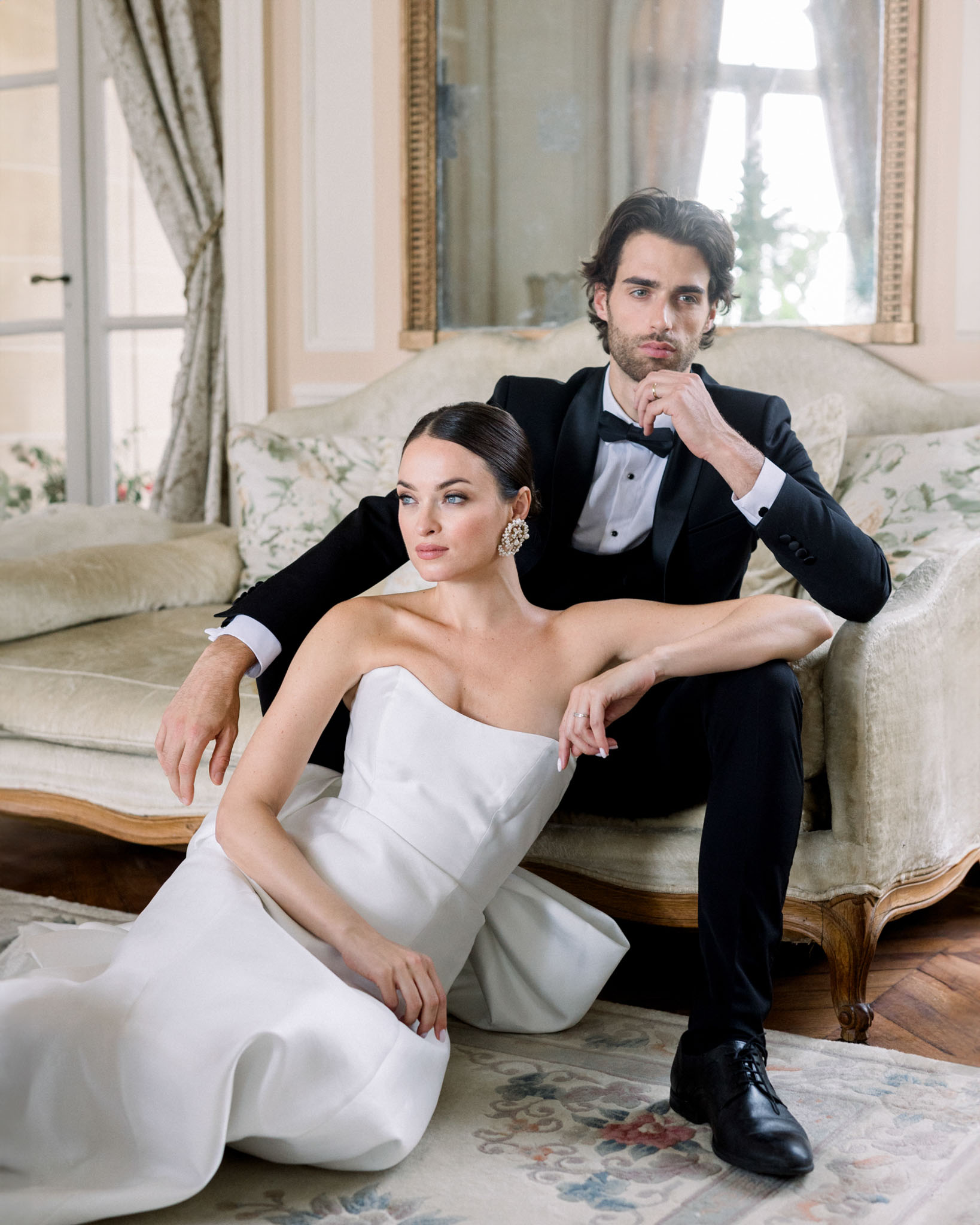 Bride and groom formal portrait in classical interior room with ornate mirror behind