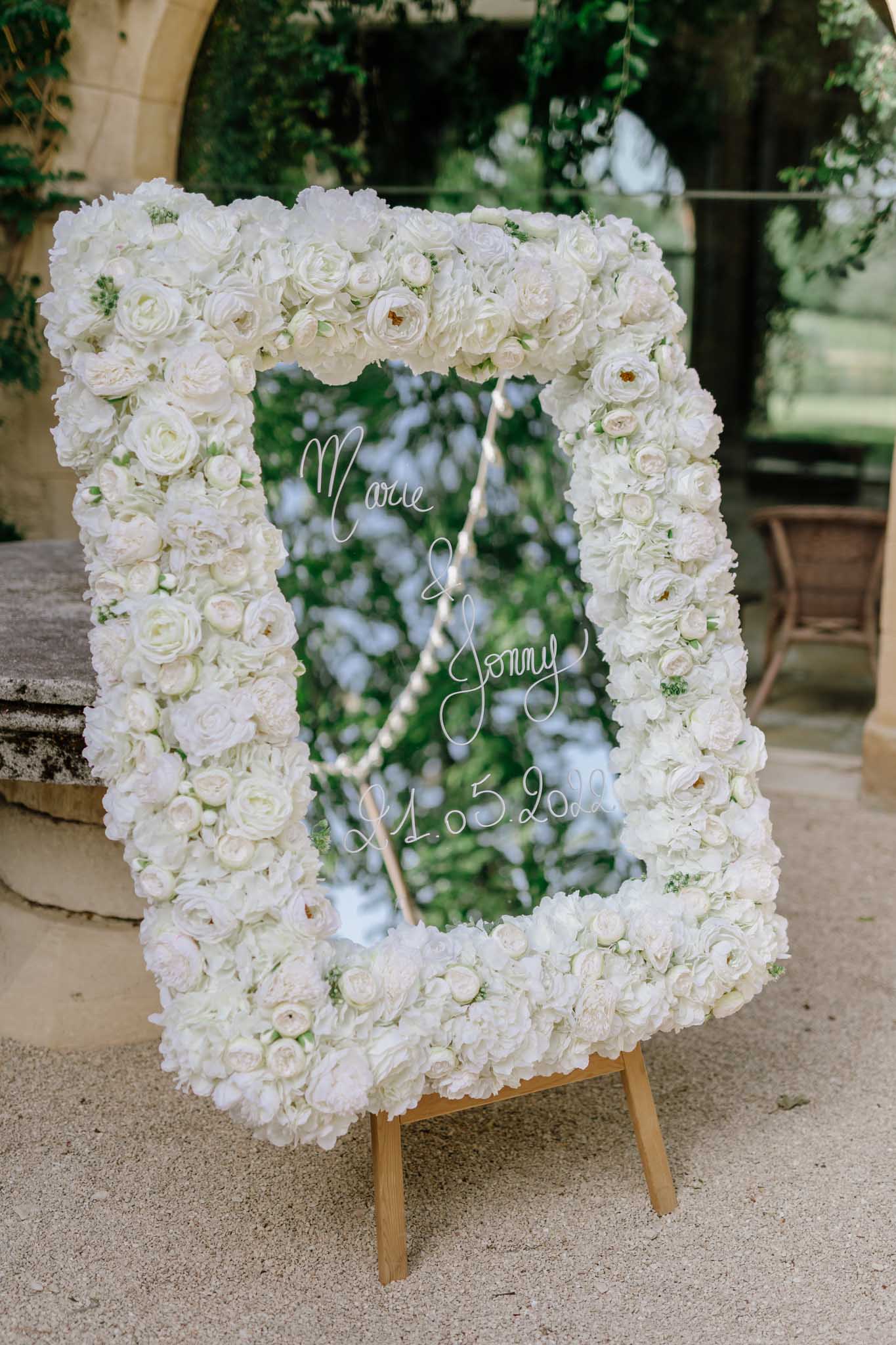 Wedding welcome sign with white frame in a garden courtyard