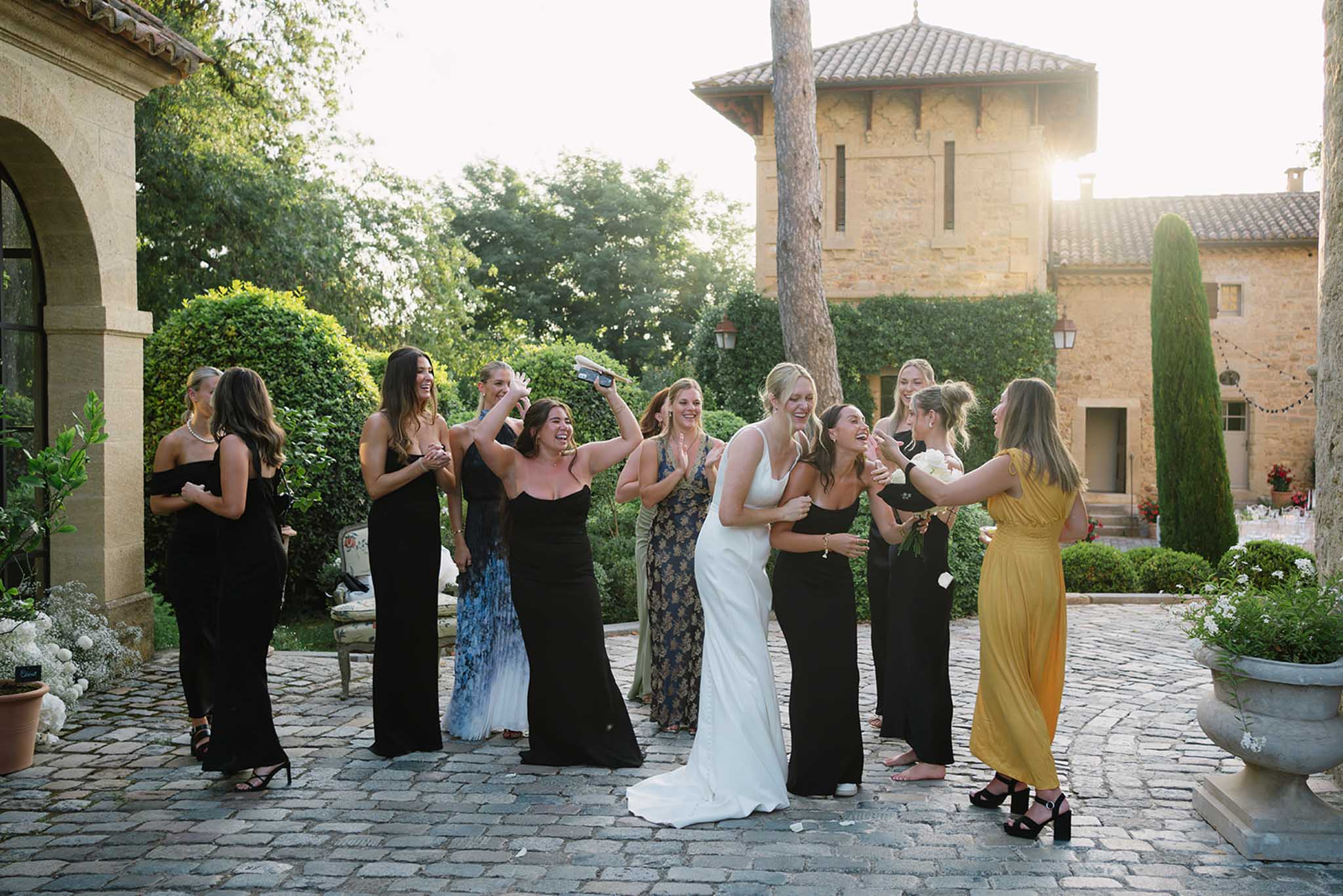 Bride and bridesmaids bouquet toss candid moment at Chateau de Fontareches by Cova Production