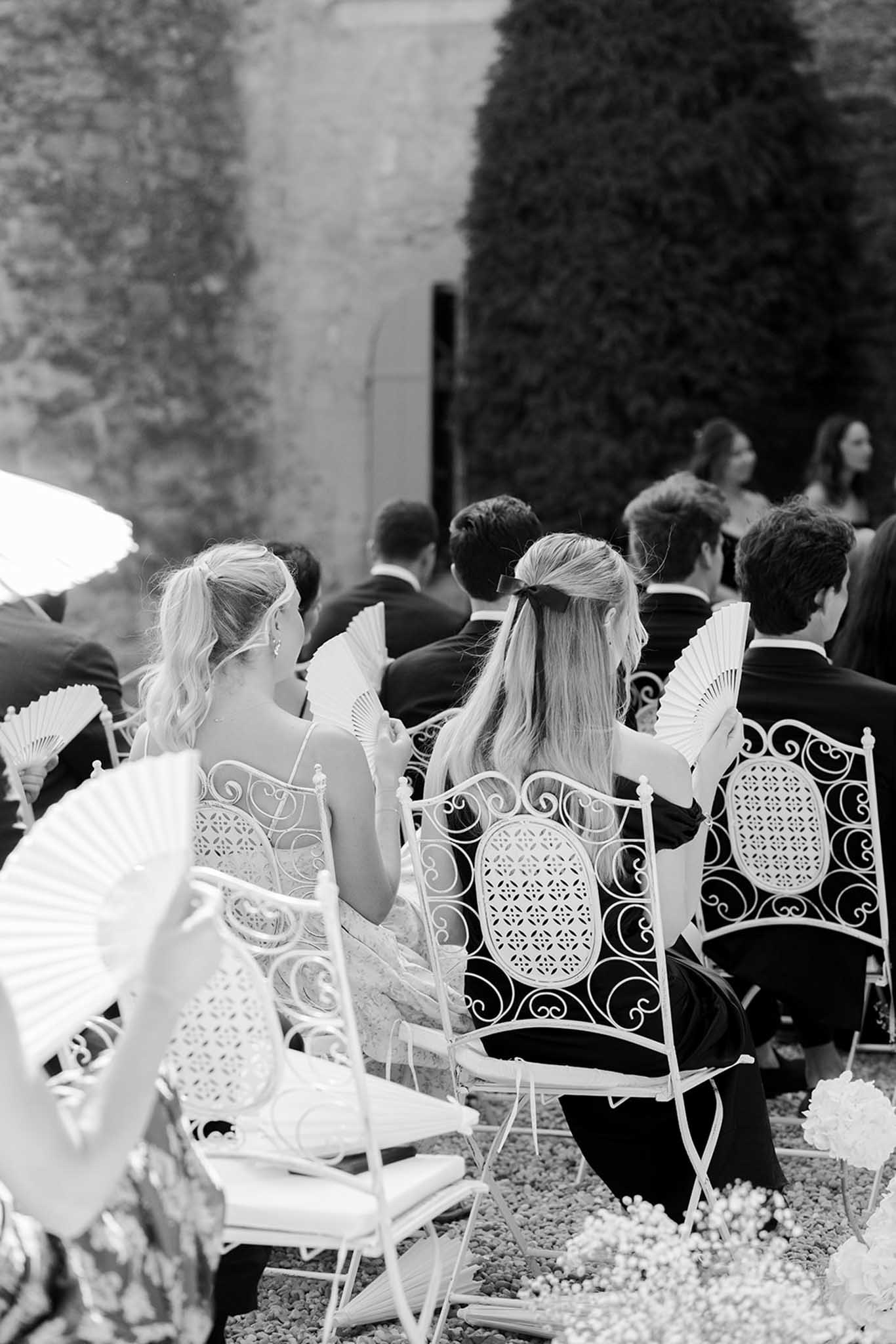 Guests seated at outdoor ceremony at Château de Fontareches, black and white photograph