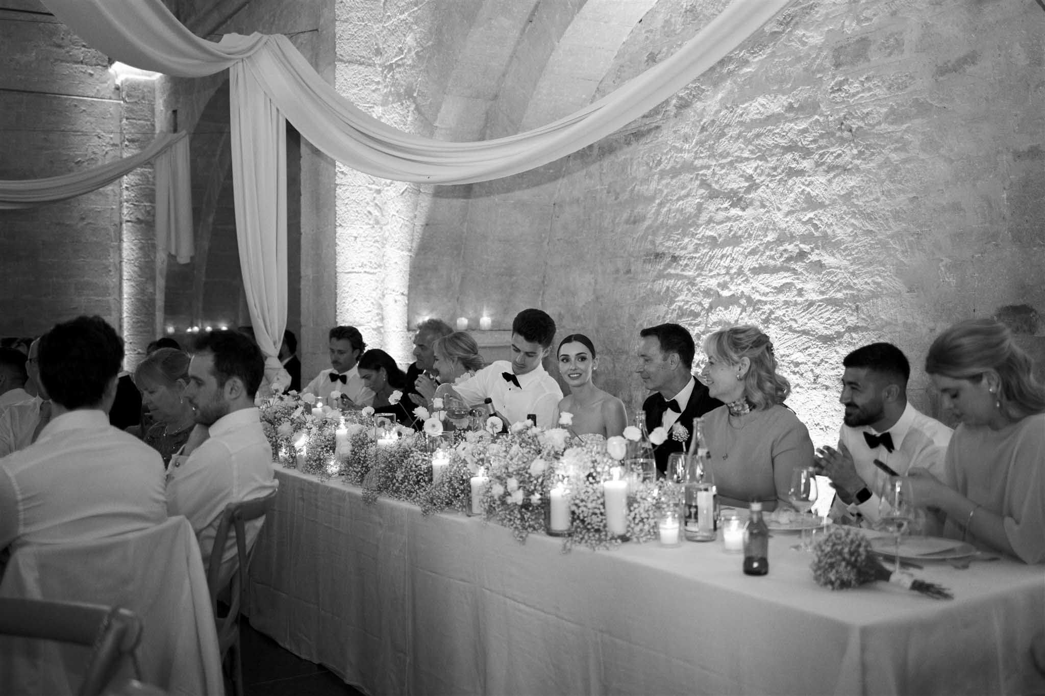Long reception table at Abbaye Saint-Eusèbe with bride and groom, black and white photograph