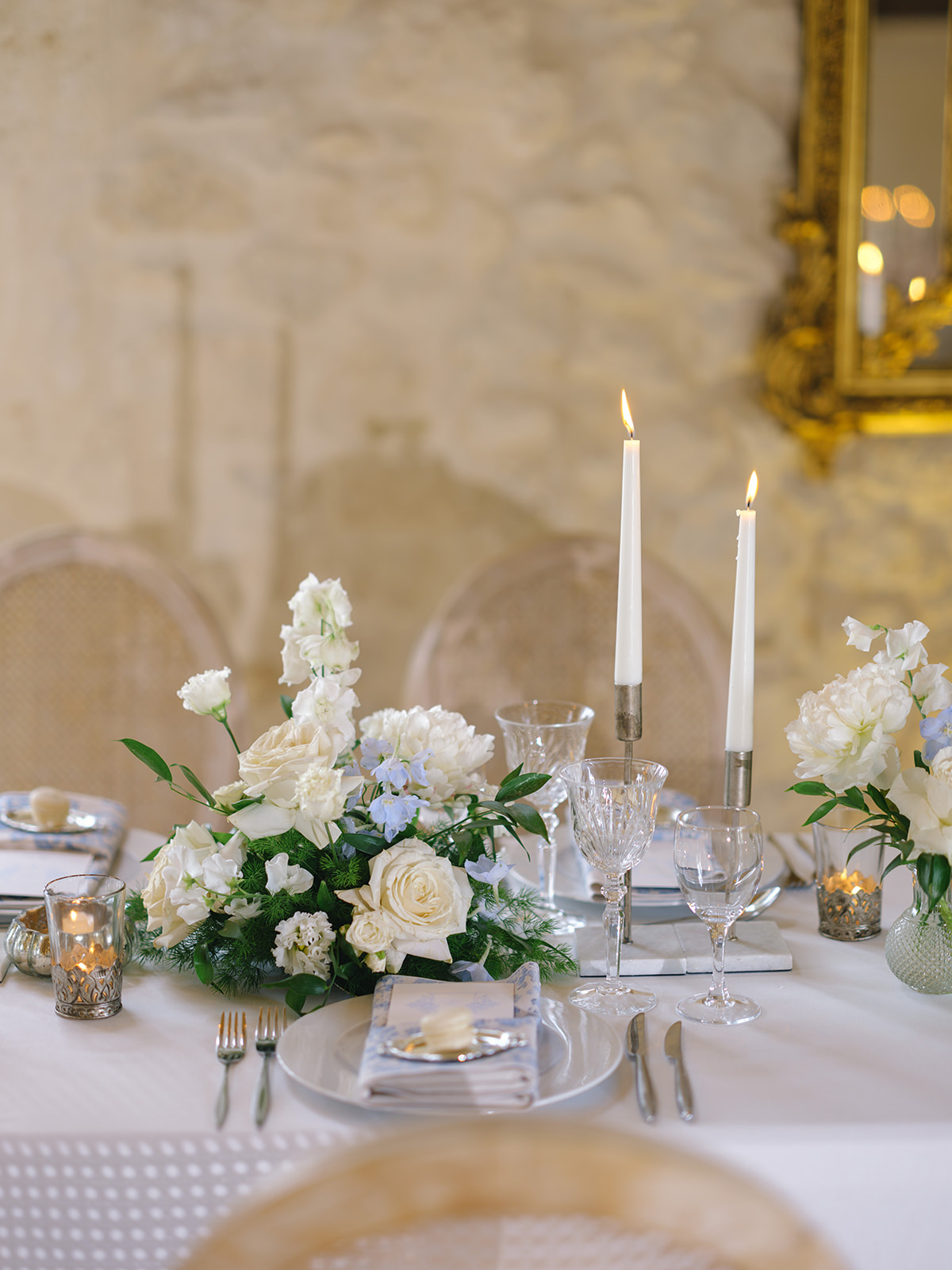 Formal reception table with ivory roses, blue delphinium centerpiece, silver candlesticks, and crystal