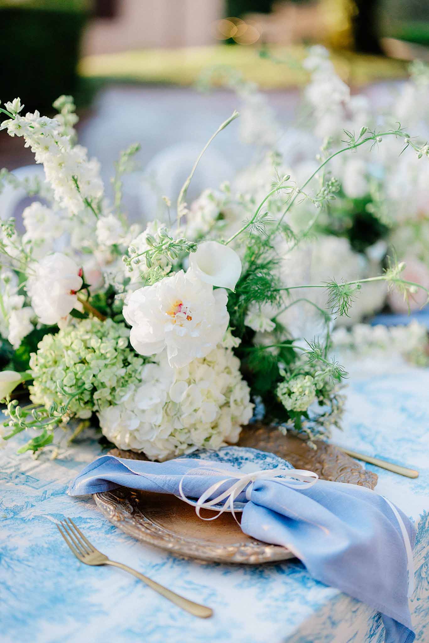 Reception table at Chateau Trieux with blue napkins, white flower centrepieces photographed by M Mann