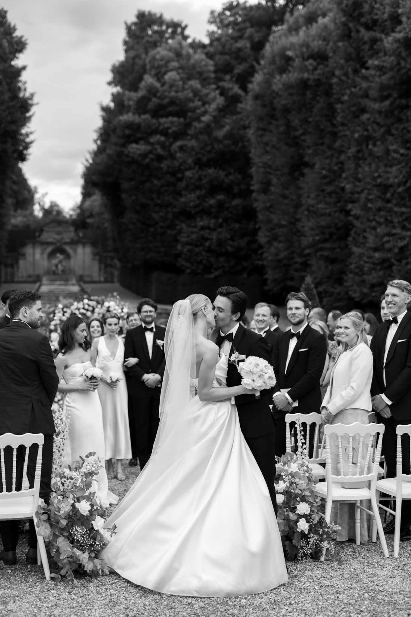 Black and white bride and groom with their bridal party in a garden setting