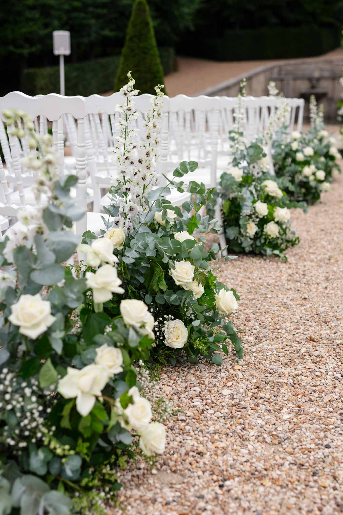 White flower arrangements lining the ceremony aisle at Château de Villette wedding