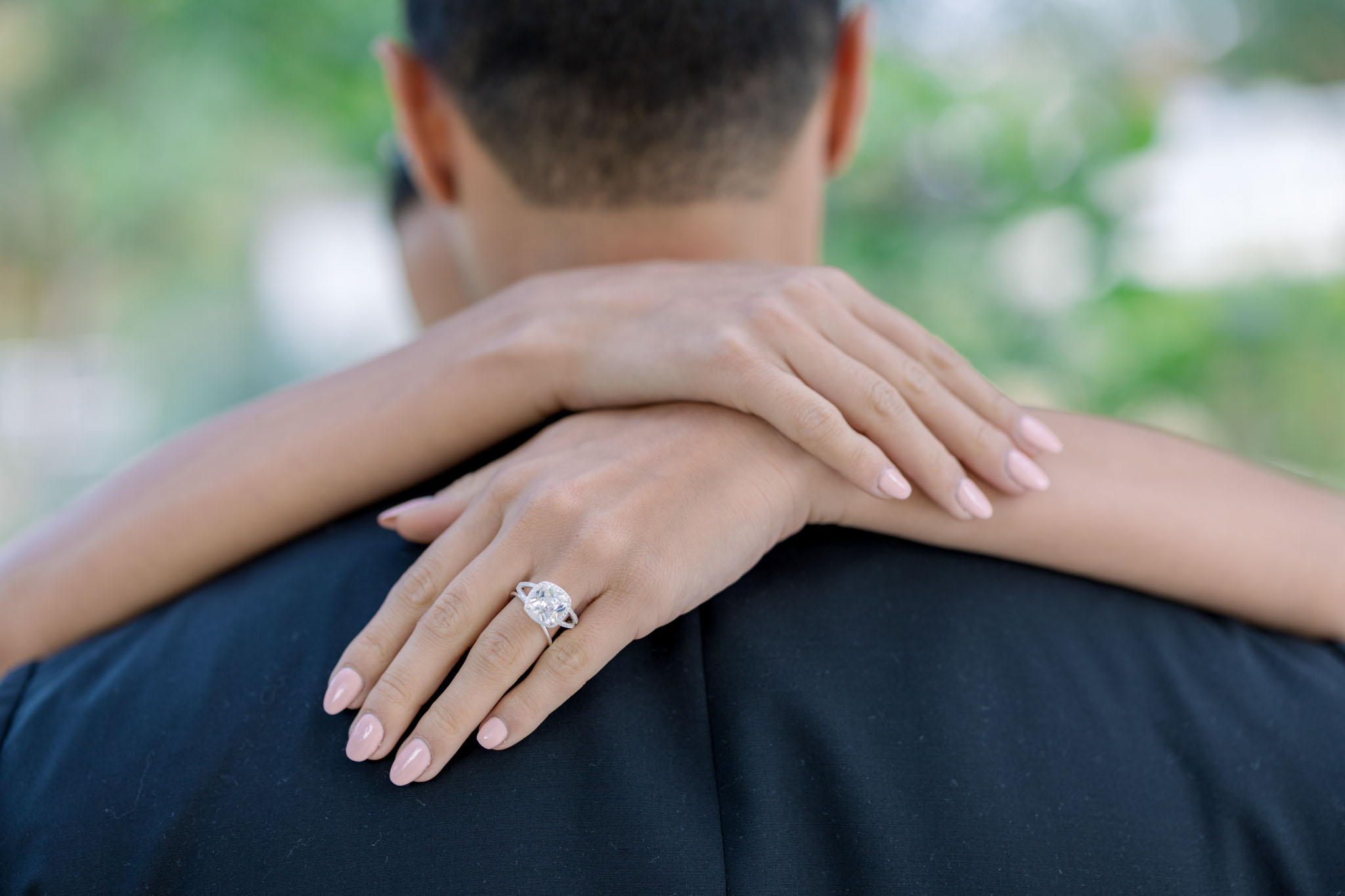 Close-up of newlyweds' hands showing diamond engagement ring and wedding bands