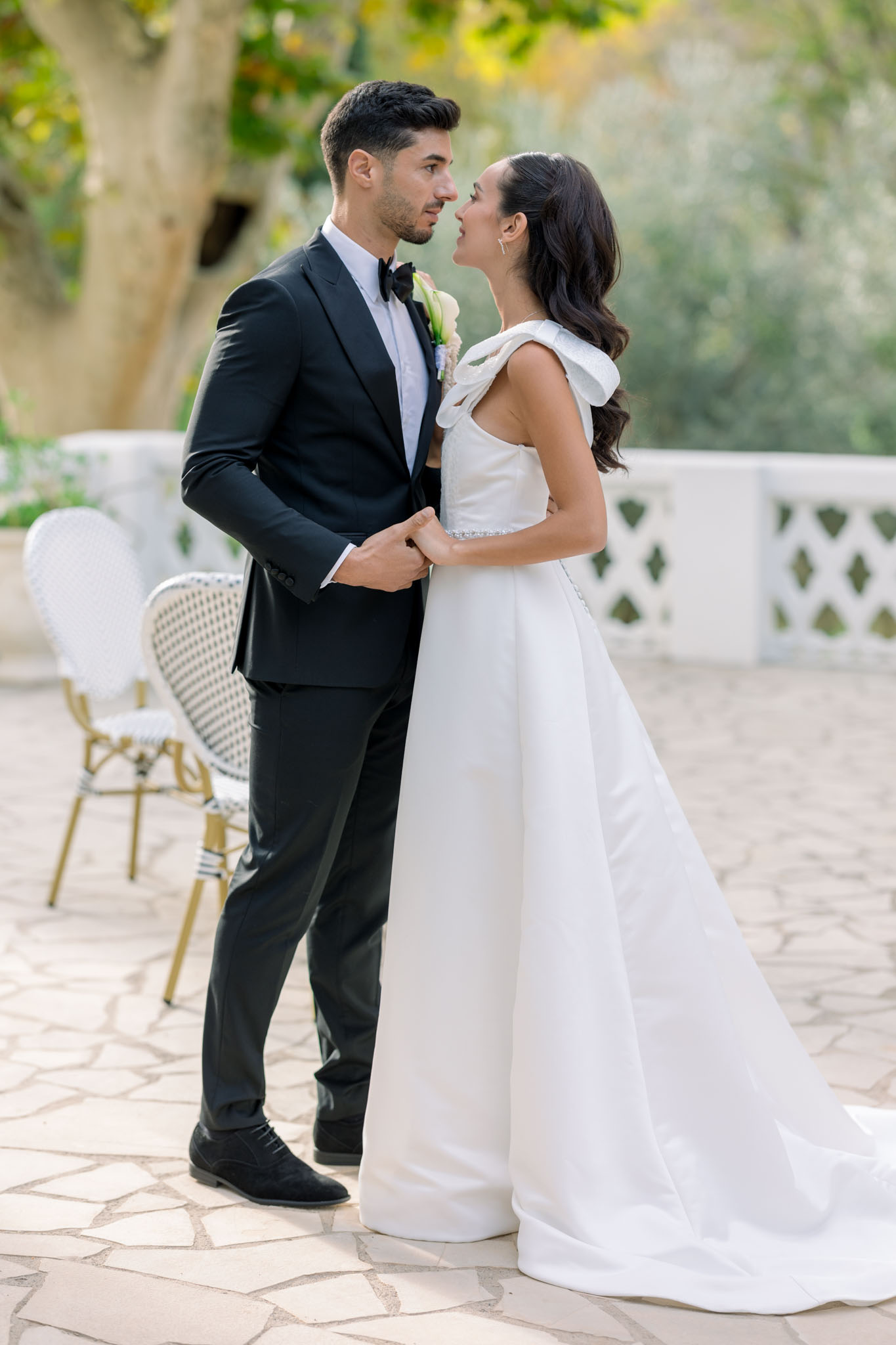 Bride and groom gazing at each other on ivy-covered stone courtyard at Chateau Pimo