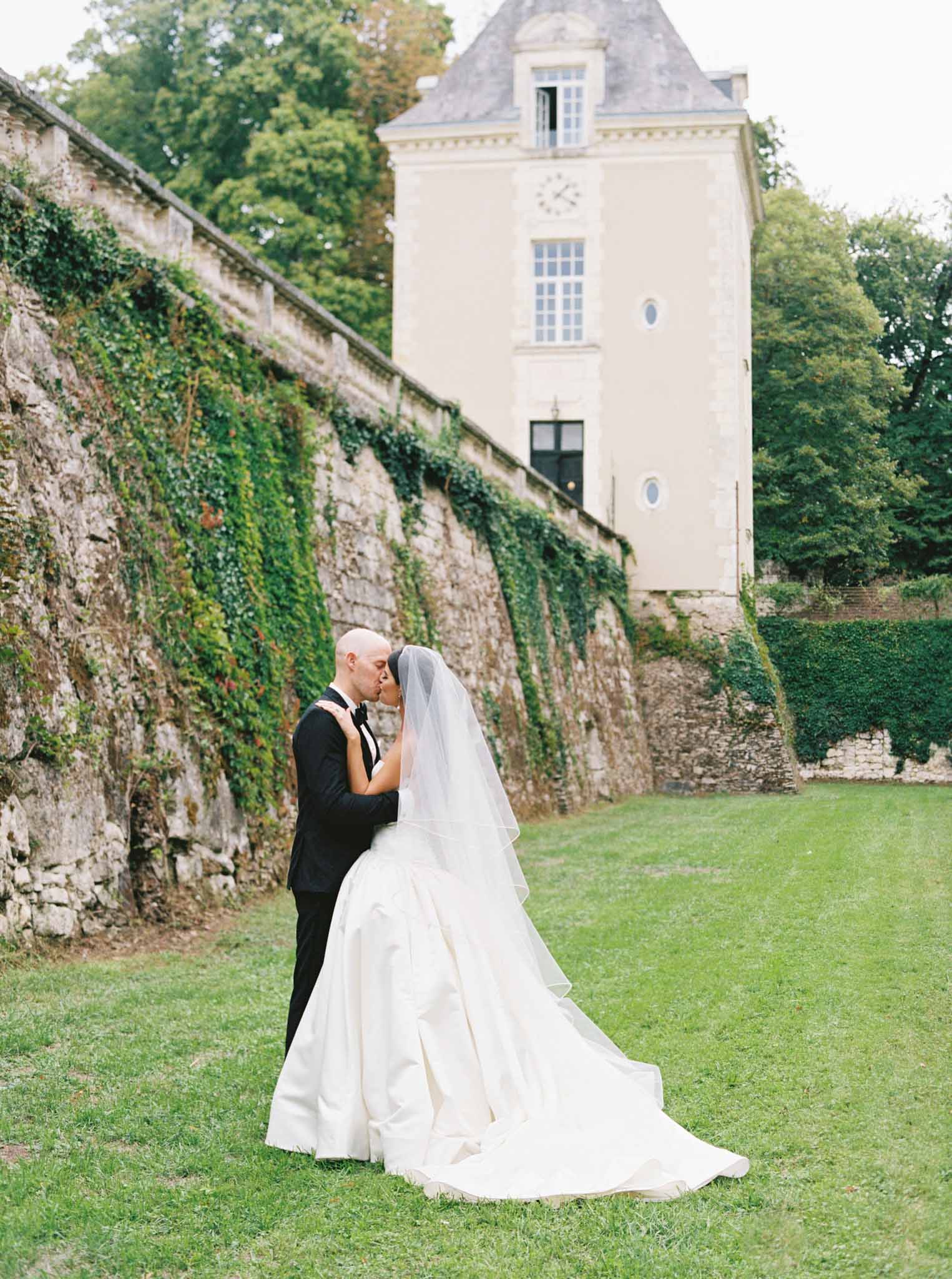 Bride and groom kissing at altar during outdoor ceremony at Chateau de Jalesnes photographed by S Lord
