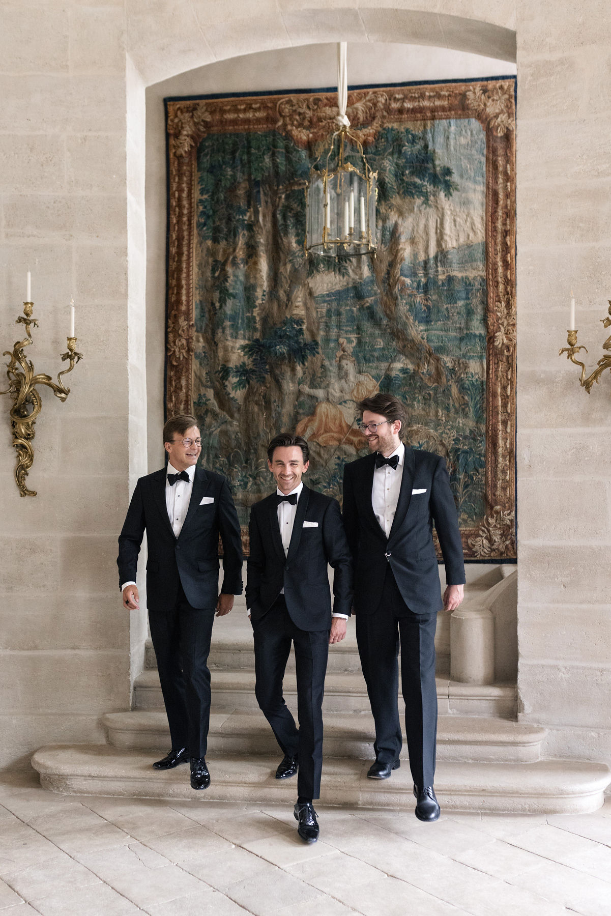 Group of groomsmen in suits standing outside Château de Villette