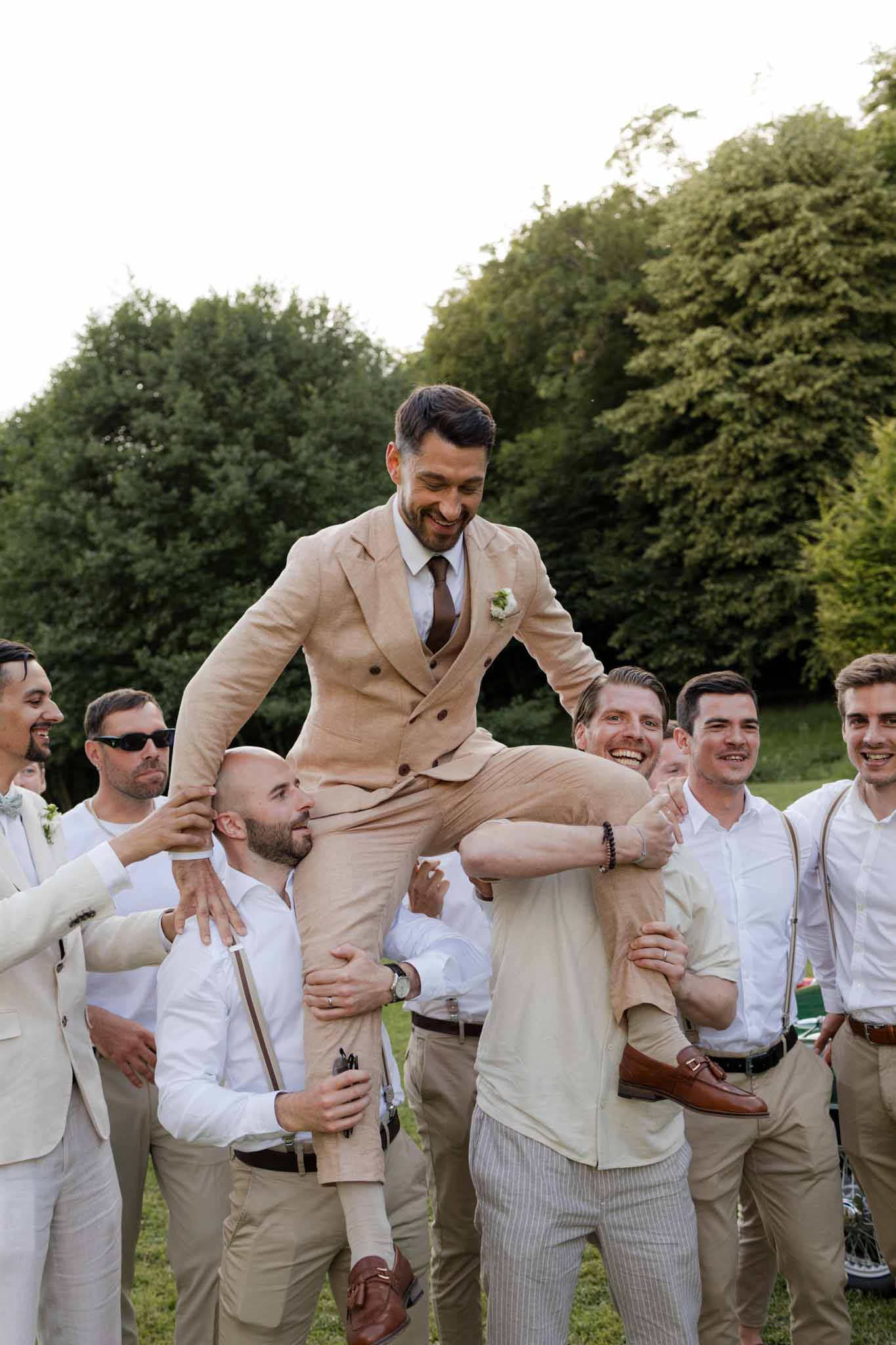 Groom lifted on groomsmen shoulders during reception celebrations