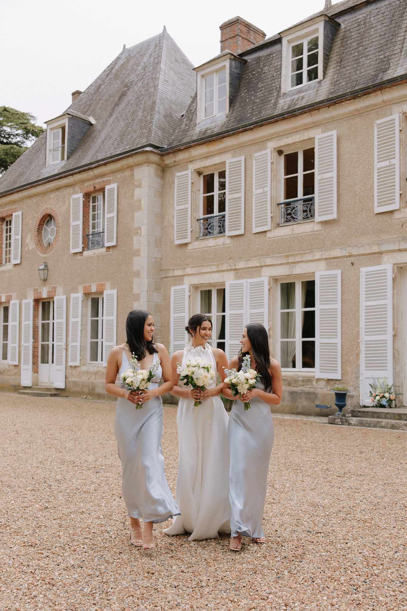 Bride and bridesmaids group photo with venue in background at Chateau de Bouthonvilliers by F Mary