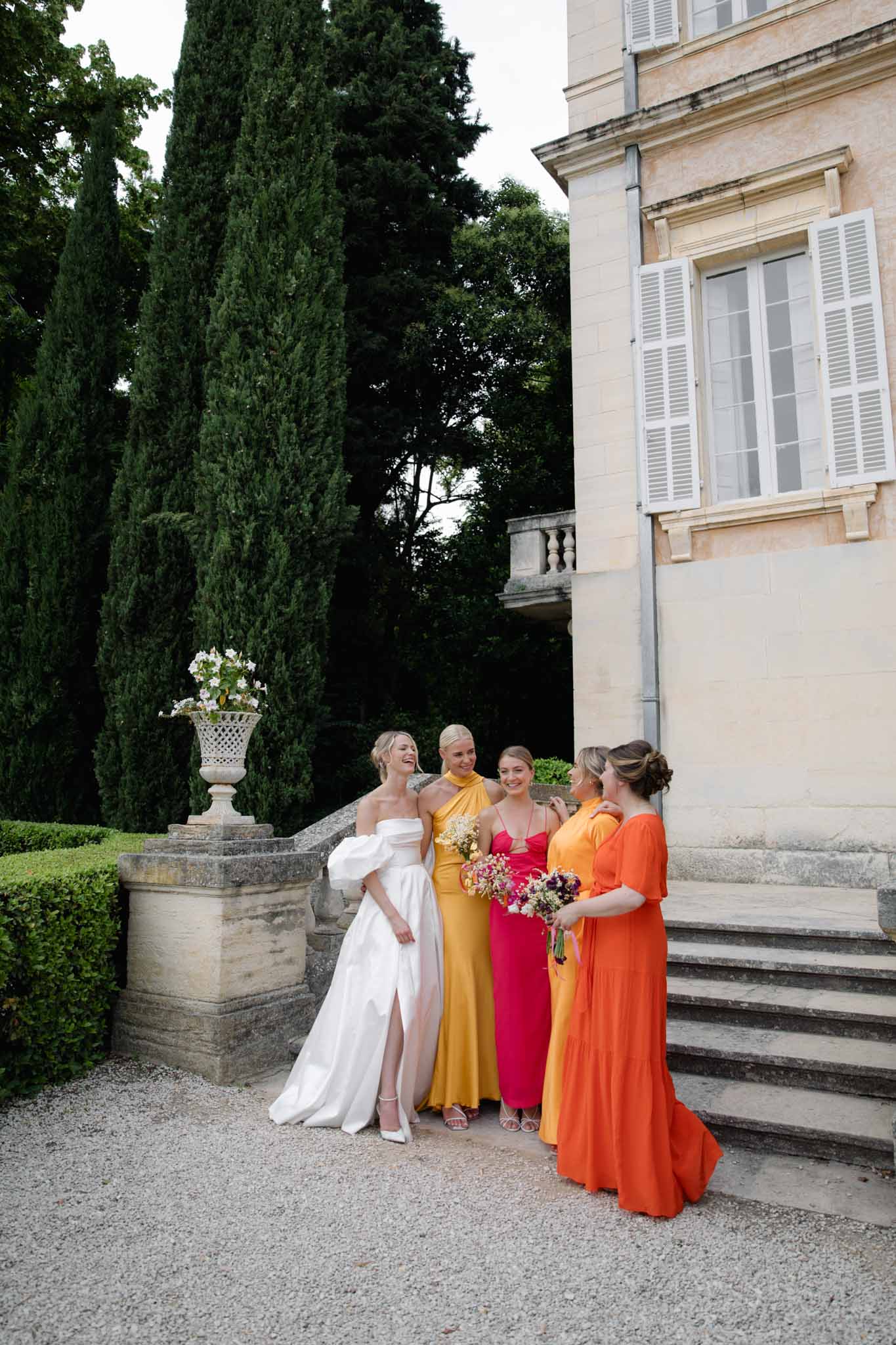Bride with bridesmaids in colourful dresses at Chateau de Martinay photographed by Despinoy
