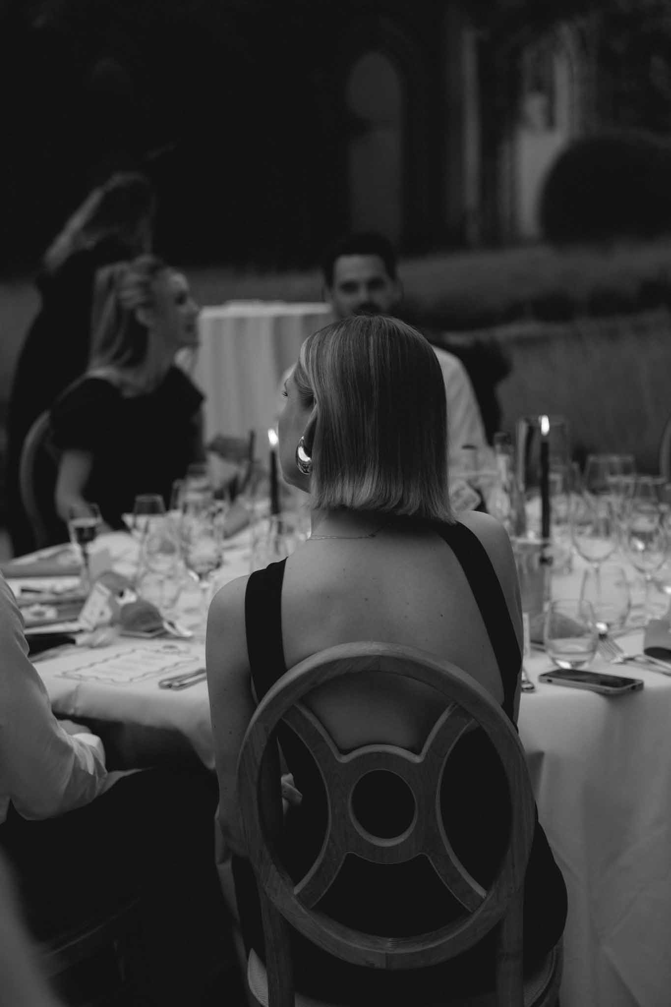 Close-up detail shot of back of guest's black and white outfit at Château de Martinay wedding