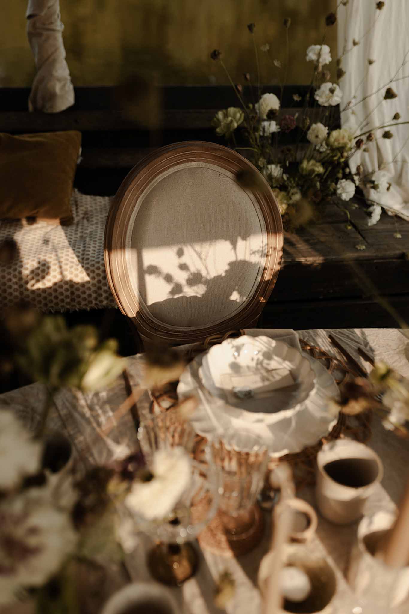 Bride seated in vintage-style reception chair with white floral décor at Loire Valley wedding venue