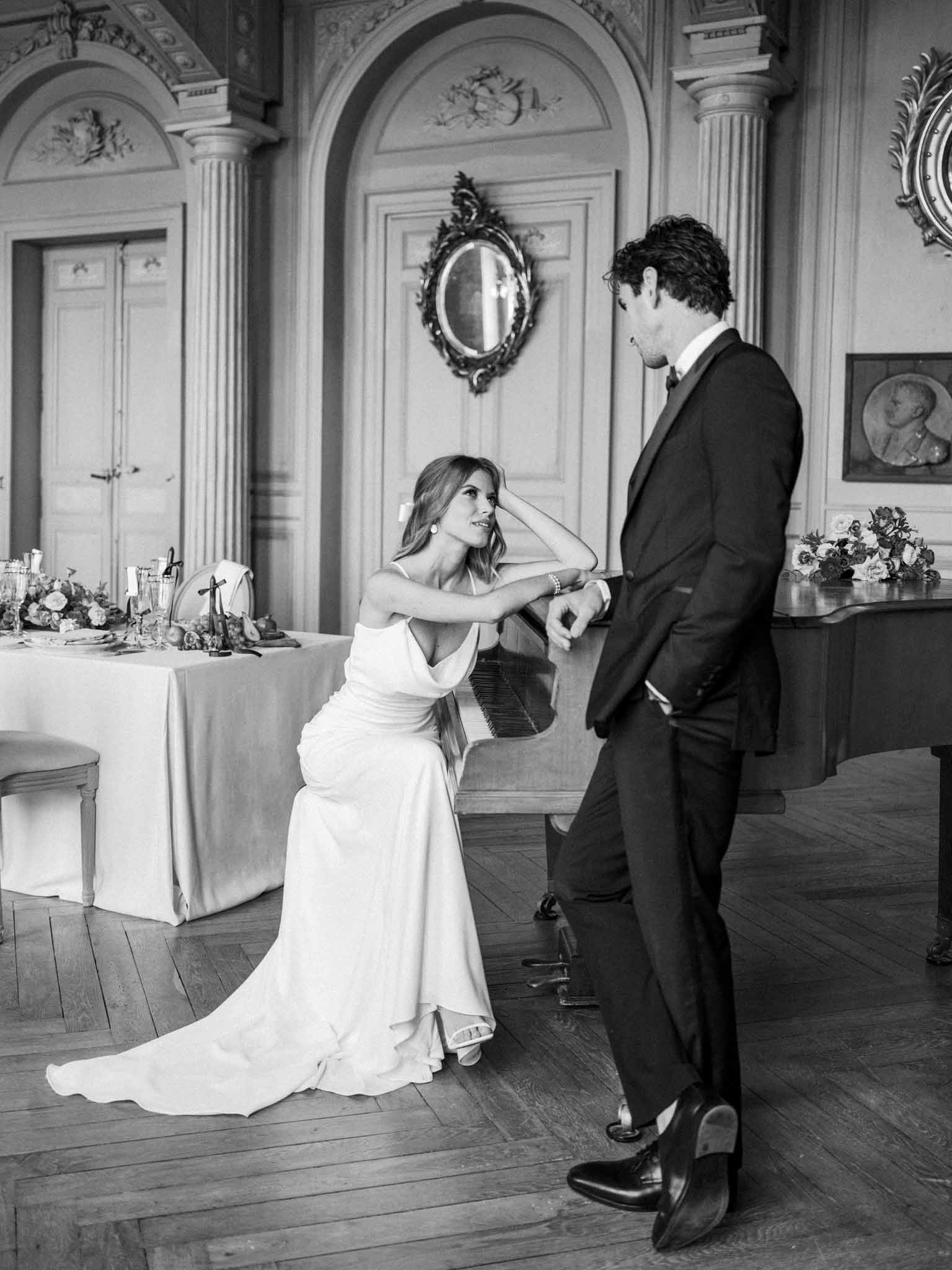 Black and white photo of couple's first dance in neoclassical ballroom with fluted columns